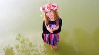 beautiful girl with red hair is standing in the water