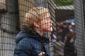 boy near the net as a fence