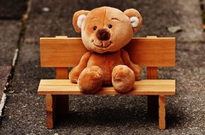 toy bear sitting on a bench