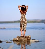 girl stands on a stone with her back