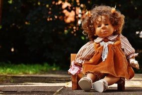 doll sitting on a chair in the park