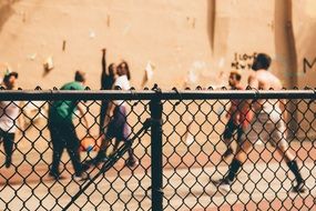 People stand behind a fence from the netting