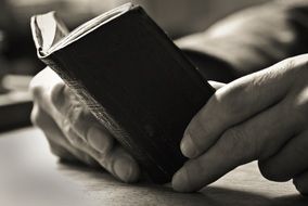 book in the hands of black and white photo