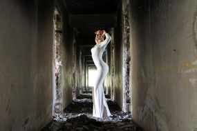girl in a white dress posing in an abandoned building