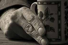 male hand holding a cup
