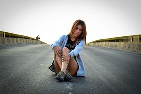 young girl sits on Highway