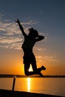 girl jumping on sunset background