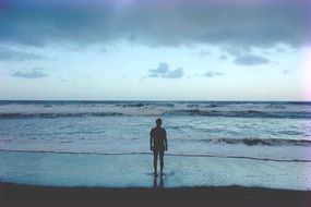 lonely man standing on the beach