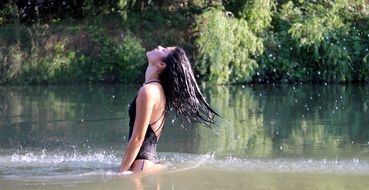 sensual brunette with long hair in spray of water