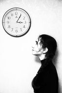 Black and white photo of a girl under the clock