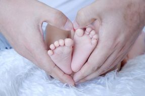 babyâs feet in Fatherâs hands