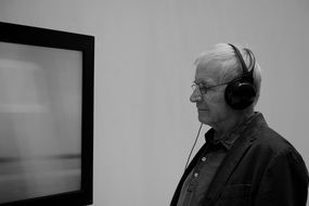 Black and white photo of the elderly man wearing headphones