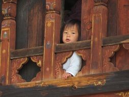 Asian kid on a wooden balcony