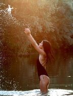 seductive model splashing in the water at dusk