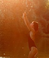 Beautiful Girl in black Swimsuit Splashing water