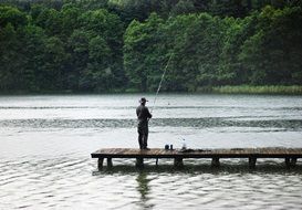 fisherman on a pier on a lake in poland