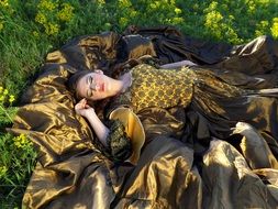 girl in a fabulous dress sleeps on green grass