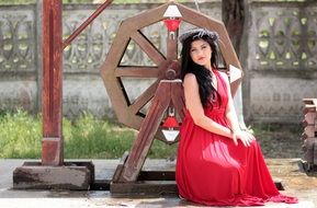 girl in a pink dress on a background of a wooden mill