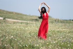 brunette in red dress on the meadow