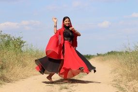 dancing Indian Girl in black and Red clothe on soil road