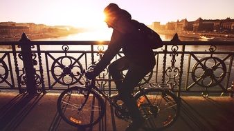 man cycling on sunset background