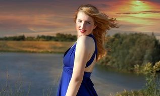 blonde woman in blue dress at sunset