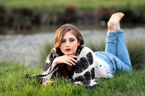 girl lying with a blanket on the green grass