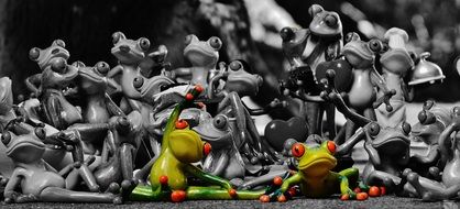 A collection of ceramic frogs in various poses, monochrome