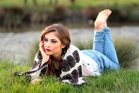 model laying on the green meadow