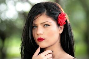 sensual brunette with a red flower in her hair