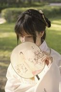 girl in a kimono with a fan in the hands of the street