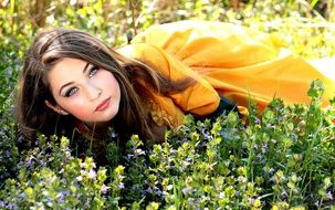 girl in a colorful dress on a flower meadow in summer