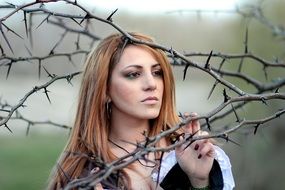 girl on the background of spiny tree branches