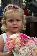 little girl with a bouquet of pastel roses