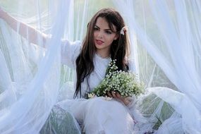 model in white dress with bouquet