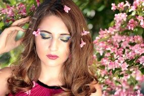 girl with closed eyes on a background of pink flowers