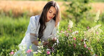 girl picks flowers from a bush