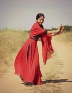 girl in the oriental dress on a rural road