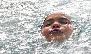 photo of a child swimming in the pool