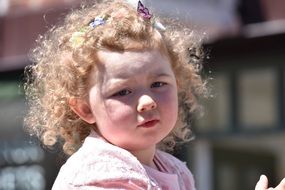face of Curly Haired blonde child girl close up