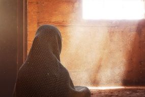 woman in a scarf sitting near the window