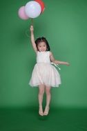 little girl is jumping with balls