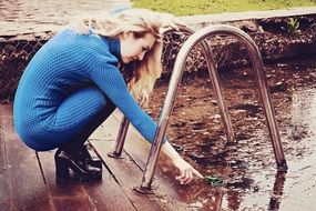 girl squatting near the lake