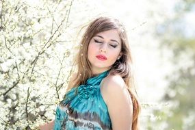 girl with closed eyes in the flowering garden