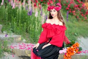 woman in rose wreath sitting among flowers