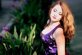 girl with long hair near a green plant