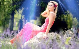 girl in pink dress posing on a stone
