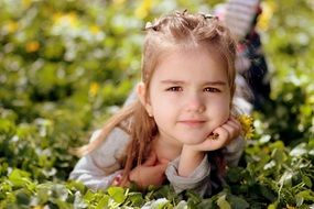 portrait of a cute little girl on green grass