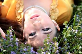 model with blue eyes lying on the meadow