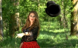 girl with colorful makeup with a hat in the forest